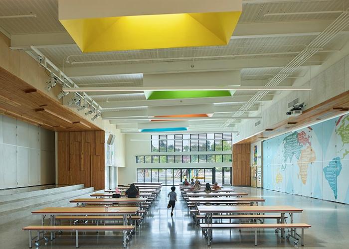 a lunchroom with a stage on one side and a map on the other